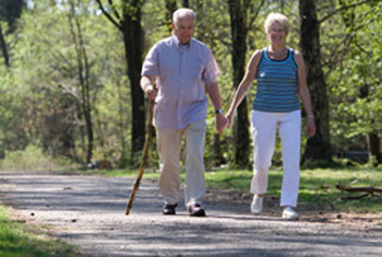 a man with a cane walking with a woman