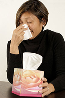 A woman blows her nose.