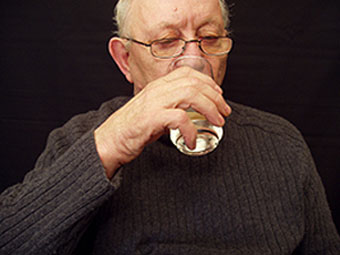 A man drinks a glass of water.