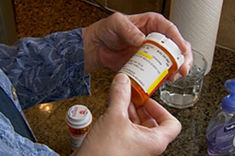 Caregiver checking label on medicine container.