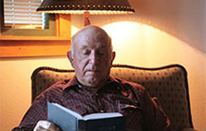 a man reads a book while seated in a chair