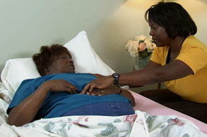 woman checking on a patient in a bed