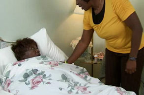 woman checking on patient in a bed